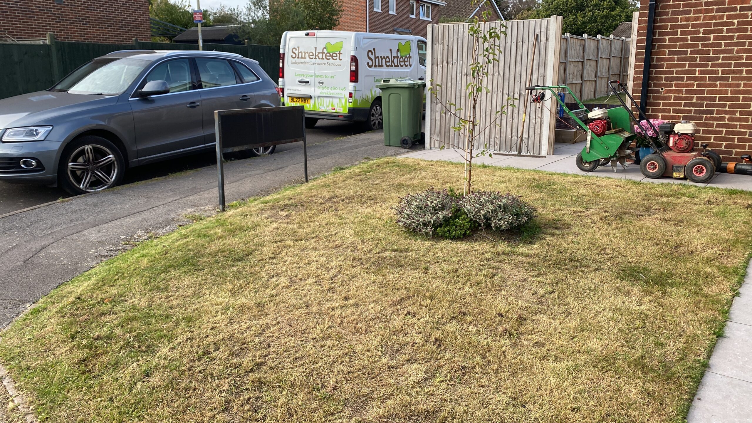 Straw-brown lawn showing drought dormancy with Shrekfeet vans in background