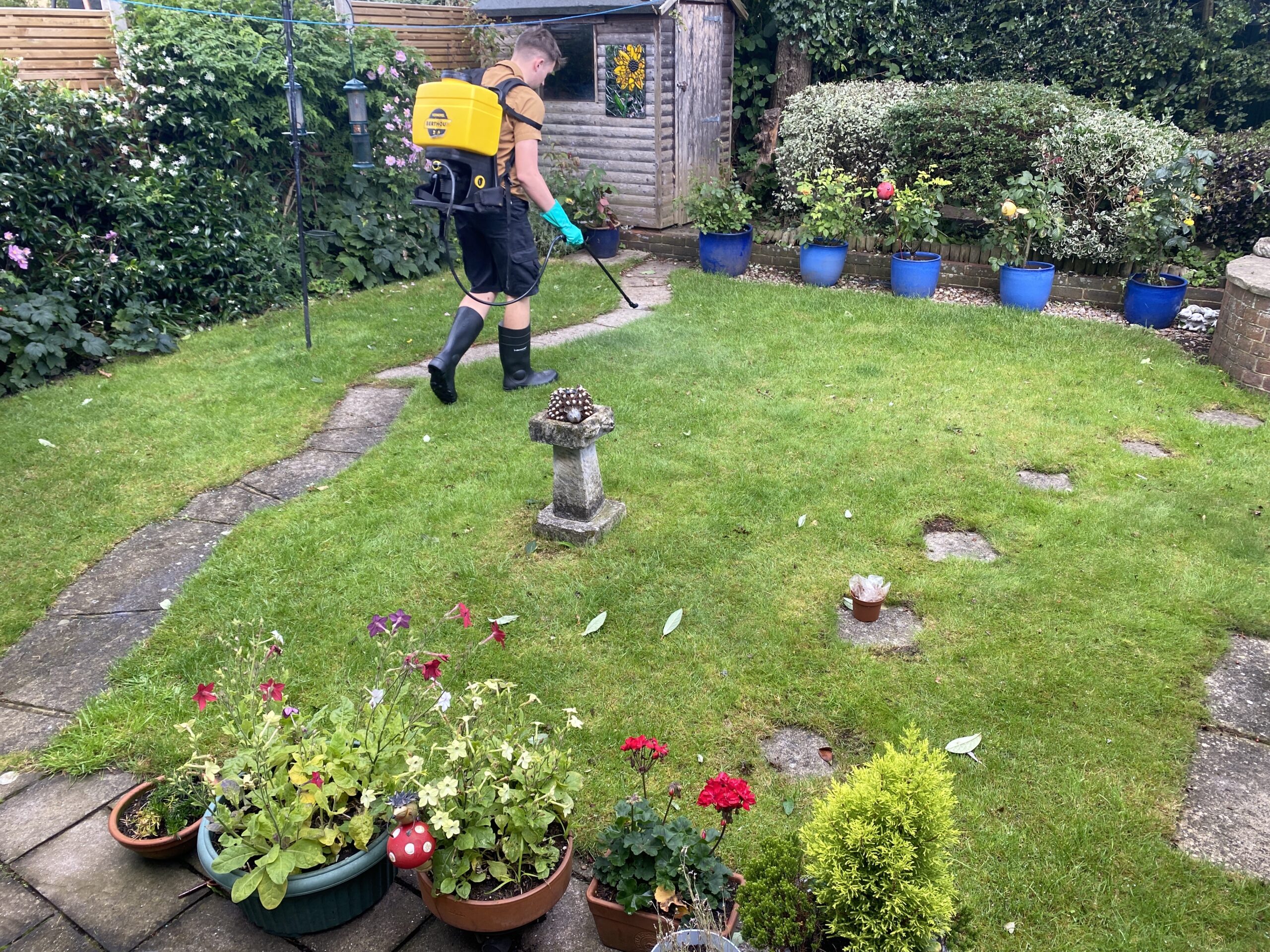 Shrekfeet technician with backpack sprayer treating a lawn